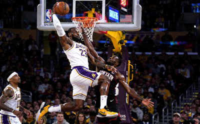 NBA常规赛中勒布朗·詹姆斯突破上篮并造成犯规的激烈对抗场景
